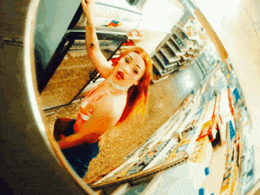 a woman in a pink top is looking at her reflection in a mirror that says patty 's cheese