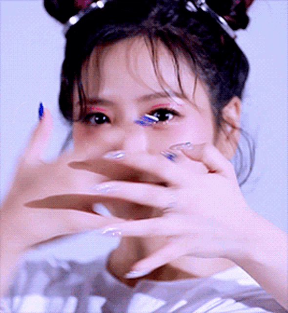a close up of a woman 's face with her hands covering her mouth