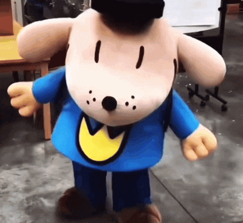 a stuffed dog wearing a blue shirt with a yellow circle around his neck