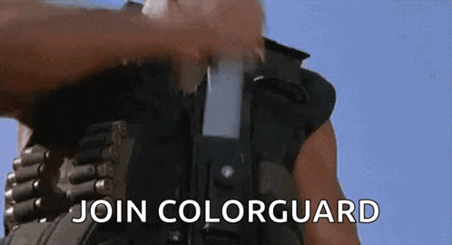 a man is holding a gun with the words `` join colorguard '' written on the screen .