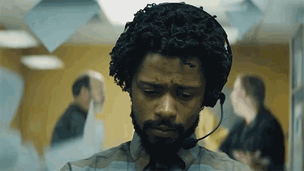 a man with a beard is wearing a headset in a call center