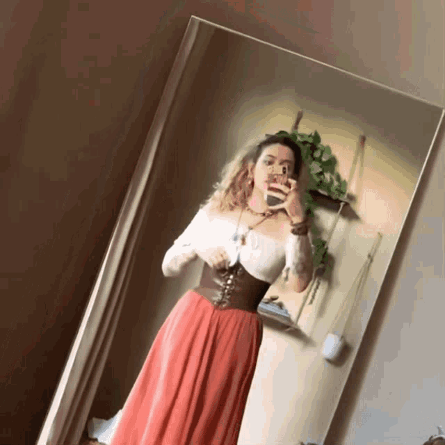 a woman taking a selfie in front of a large mirror