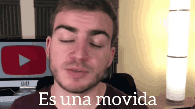 a man with his eyes closed and the words es una movida above him