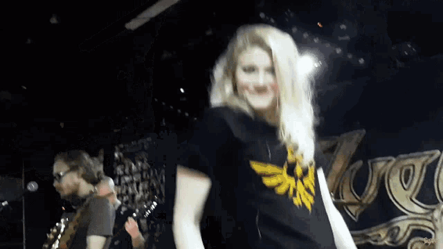 a woman wearing a black shirt with a zelda logo on the front