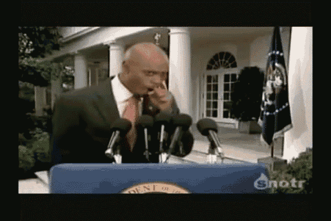 a man in a suit and tie is standing at a podium with microphones in front of a white house