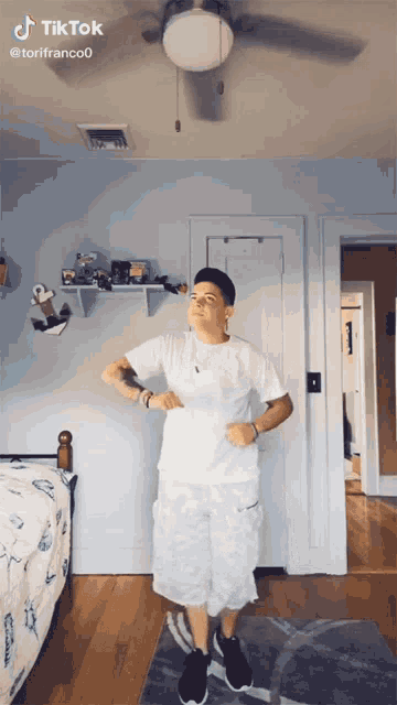 a man is dancing in a bedroom with a ceiling fan behind him and a tiktok watermark