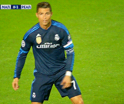 a soccer player wearing a blue emirates jersey is pointing