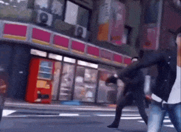 two people are walking down a street in front of a convenience store .