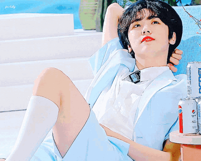 a man in a blue suit is laying on a couch next to a can of pepsi