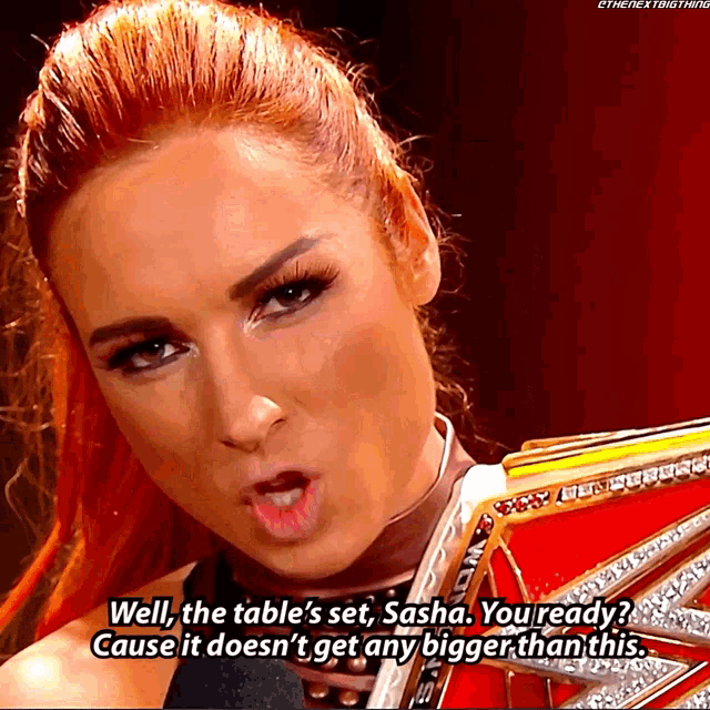 a woman with red hair is holding a championship belt and says well the table 's set sasha