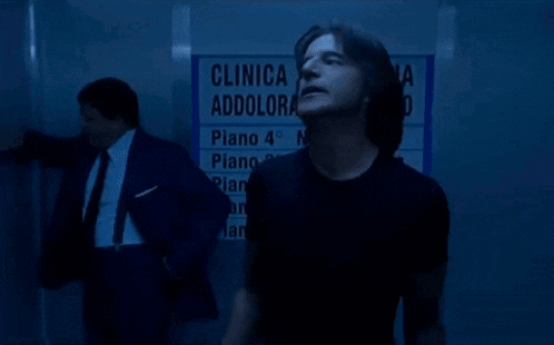 a man stands in front of a sign that says clinica s.s.
