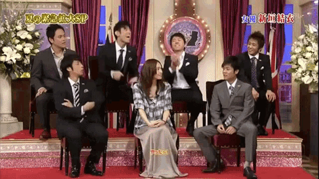 a group of people are sitting on a stage with a sign that says sp