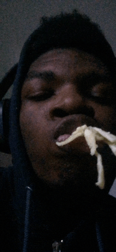 a man wearing headphones is eating a slice of pizza