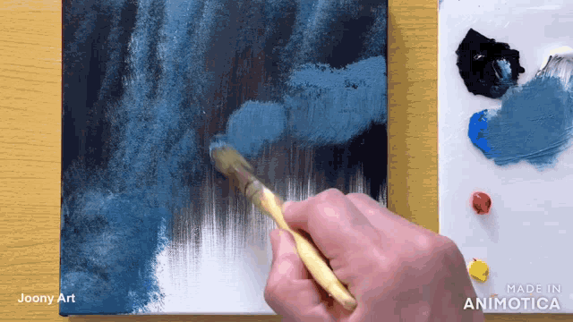 a person is painting on a canvas with a made in animatica logo