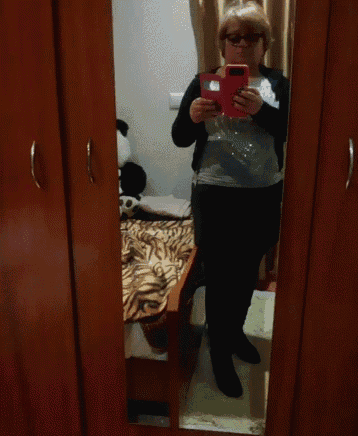a woman takes a selfie in front of a mirror