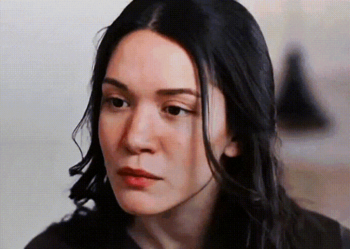 a close up of a woman 's face with long dark hair