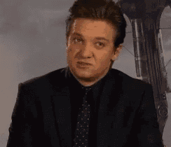 a man in a suit and tie is making a face