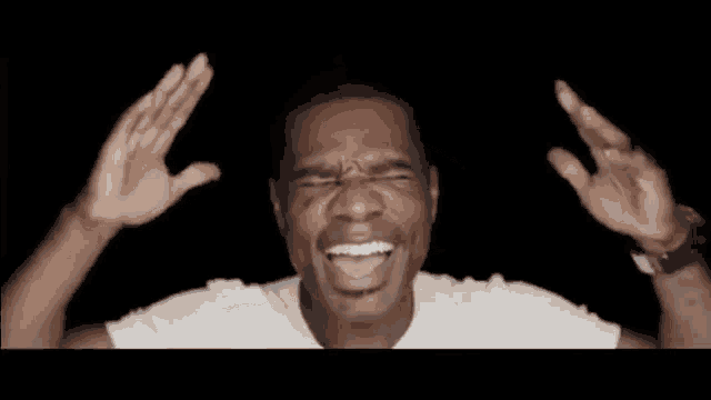 a man in a white shirt is making a funny face while holding a glass of water .