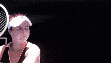 a blurry picture of a woman playing tennis with the letter l visible in the background