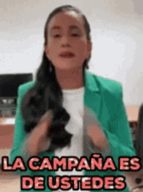 a woman in a green jacket says la campana es de ustedes in spanish