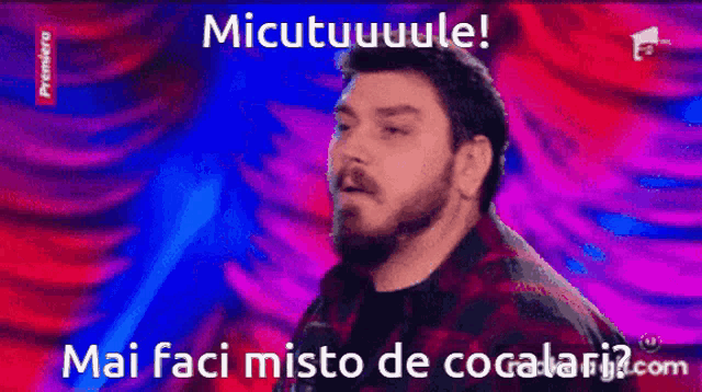 a man with a beard stands in front of a colorful background with the words micutuuuule written on it