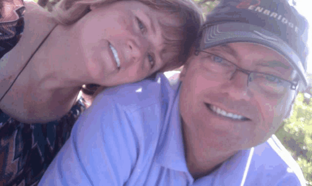 a man and woman are posing for a picture and the man is wearing a denbridge baseball cap
