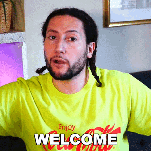 a man wearing a yellow t-shirt that says enjoy welcome