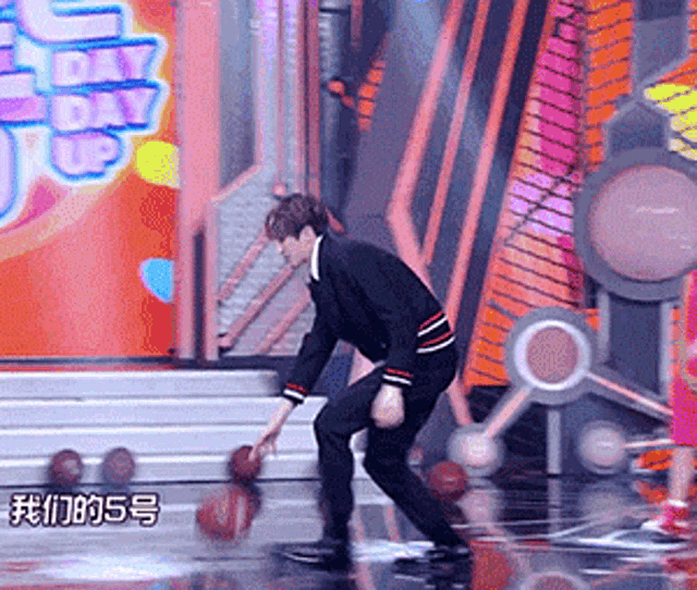 a man playing basketball on a stage in front of a sign that says ' day day up '