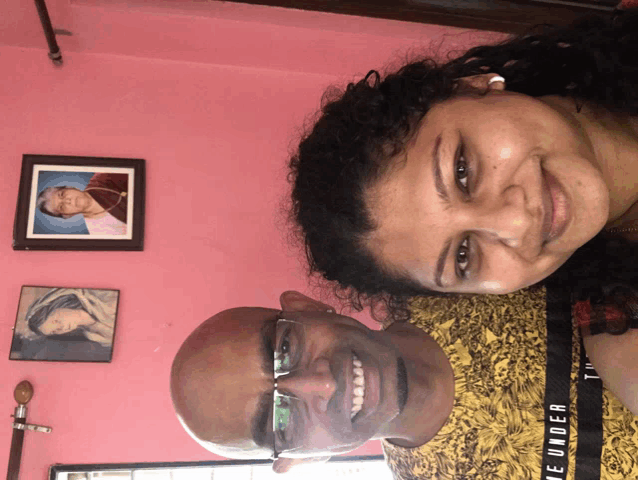 a man and a woman are posing for a picture and the man is wearing a yellow shirt that says " the under "