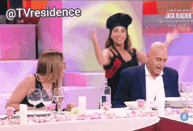 a woman in a chef 's hat is dancing in front of a man and two women