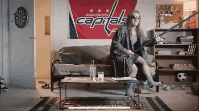 a woman is sitting in front of a washington capitals banner