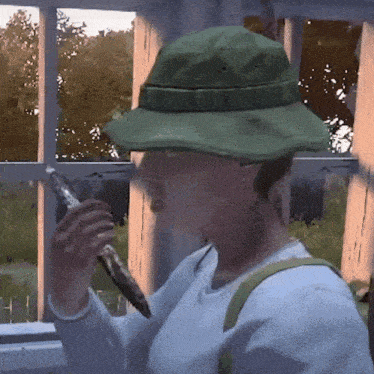 a person wearing a green hat is holding a piece of paper
