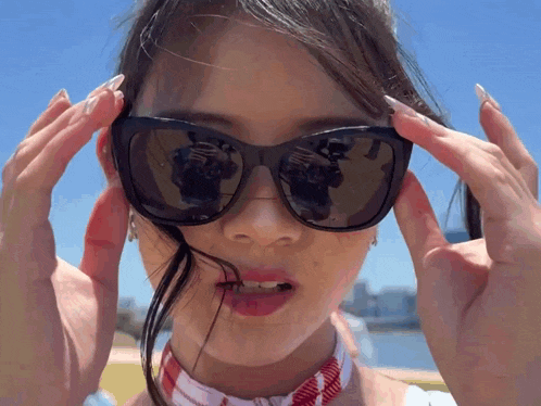a woman wearing sunglasses has a reflection of herself in the sunglasses