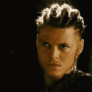 a young man with braids on his head is smiling