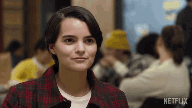 a woman in a plaid shirt with netflix written on the bottom right