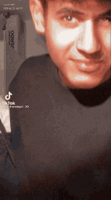 a close up of a man 's face with a conair hairdryer in the background