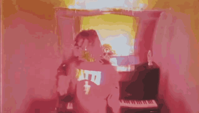 a person wearing a shirt that says atta is playing a piano