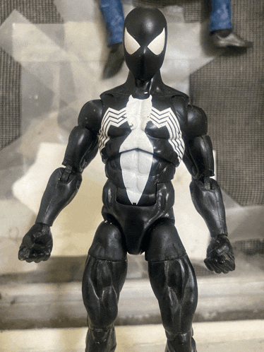 a black spiderman action figure with a white chest