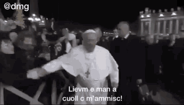a man in a white robe is dancing in front of a crowd .