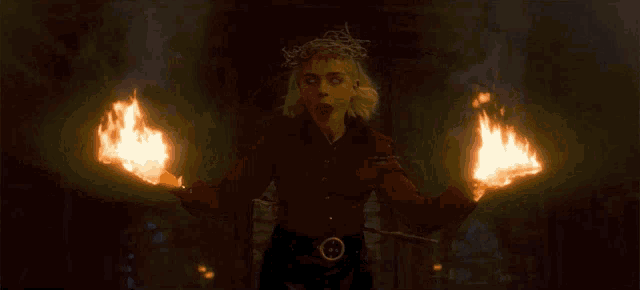 a woman with a crown of thorns on her head is holding fire in her hands and says " praise satan "