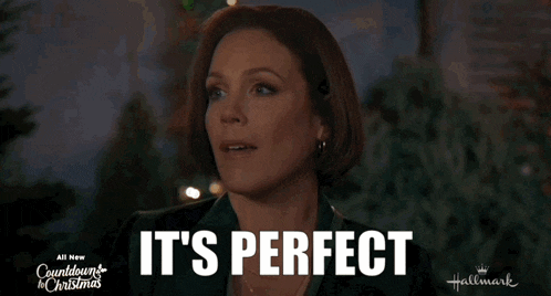 a woman is standing in front of a christmas tree and says it 's perfect