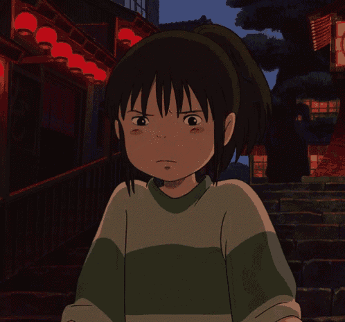 a girl in a green and white shirt wipes her eyes