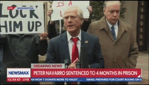 a man in a suit and tie holds a sign that says lock him up