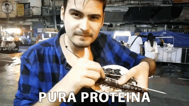 a man in a plaid shirt is holding a plate of food that says pura proteina on the bottom