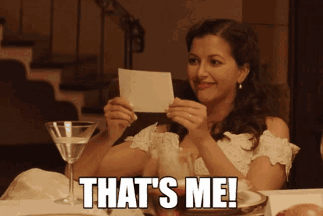 a woman holding a piece of paper with the words that 's me written on it