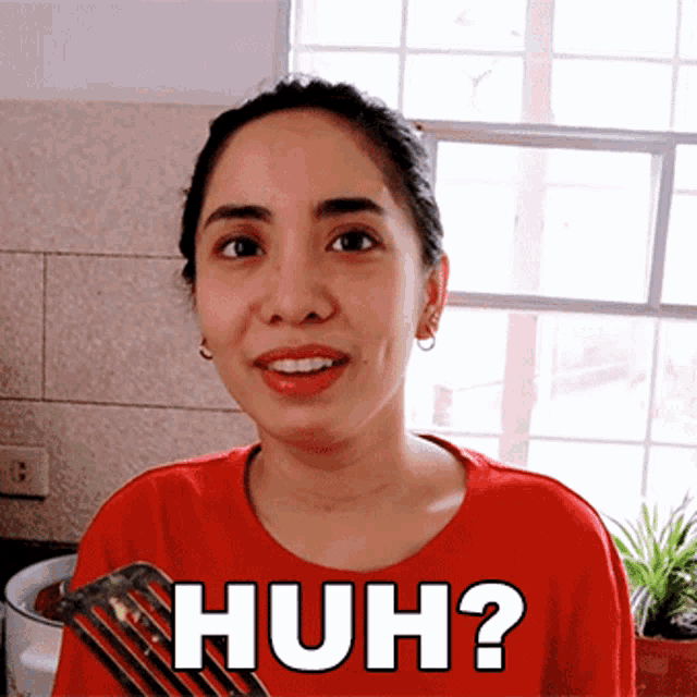 a woman in a red shirt is holding a fork and says huh ?