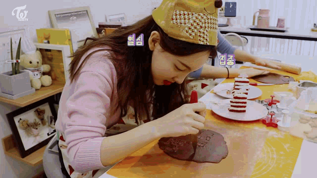 a woman wearing a hat is making a cake
