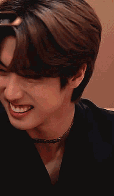 a close up of a young man 's face with a choker around his neck