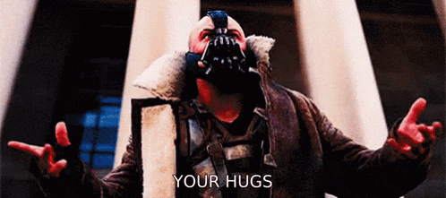 a man wearing a mask and a jacket is giving a hug .