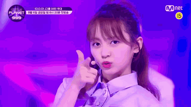 a girl is giving a thumbs up sign while standing on a stage .